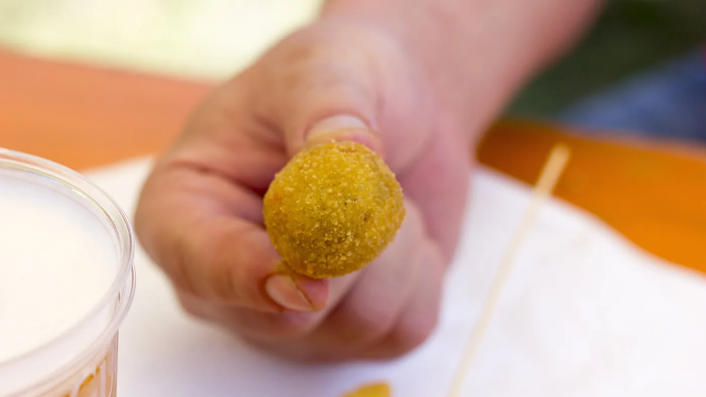 Un'oliva all'ascolana fritta, tenuta in mano