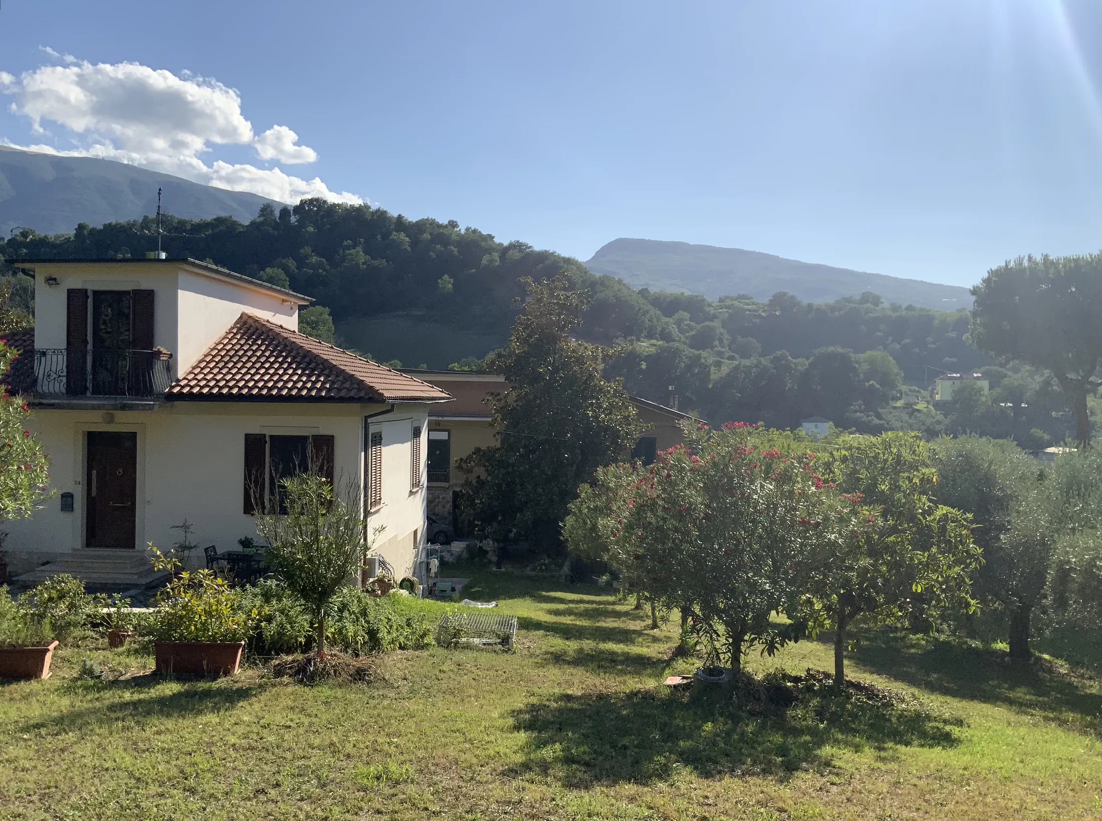 La casa vista dal prato con le colline sullo sfondo